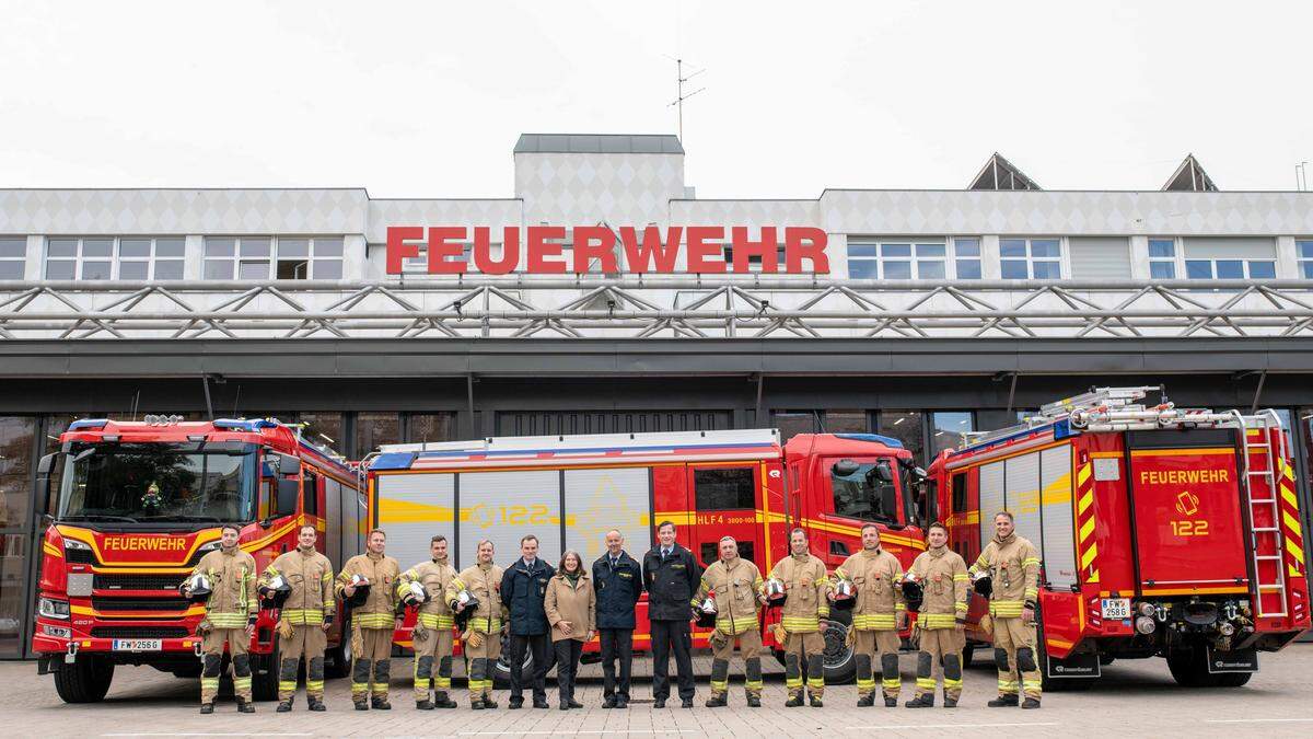 Bürgermeisterin Elke Kahr (KPÖ) und die Spitze der Berufsfeuerwehr mit den drei neuen Löschfahrzeugen