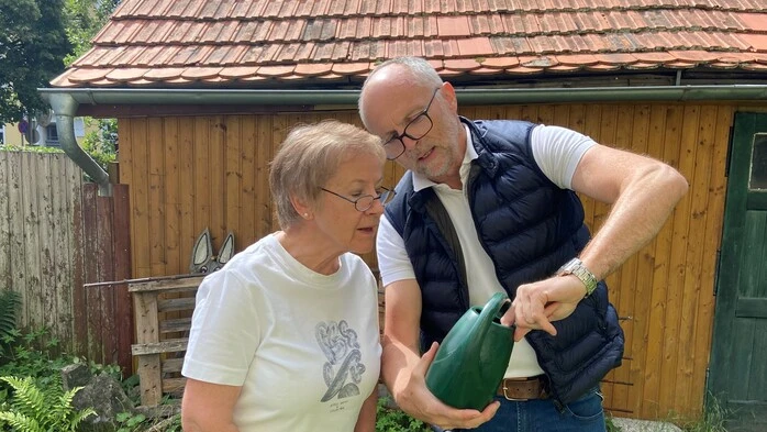 Erwin Wieser zeigt einer Anrainerin, wo Tigermücken in der Gießkanne ihre Eier ablegen