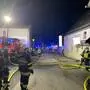 Foto vom Einsatzort, Feuerwehrmänner stehen vor dem Gebäude
