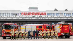 Bürgermeisterin Elke Kahr (KPÖ) und die Spitze der Berufsfeuerwehr mit den drei neuen Löschfahrzeugen