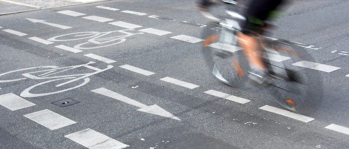 Ein Fahrrad fährt auf einem Radstreifen. Bewegungsunschärfe suggeriert hohe Geschwindigkeit