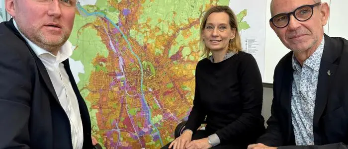 Hans Schaffer und Christian Krainer von der ÖWG mit Birgit Leinich vom ÖSW mit dem Flächenwidmungsplan der Stadt Graz