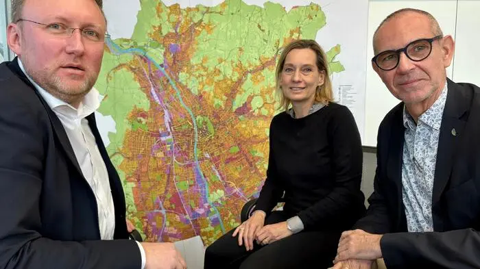 Hans Schaffer und Christian Krainer von der ÖWG mit Birgit Leinich vom ÖSW mit dem Flächenwidmungsplan der Stadt Graz