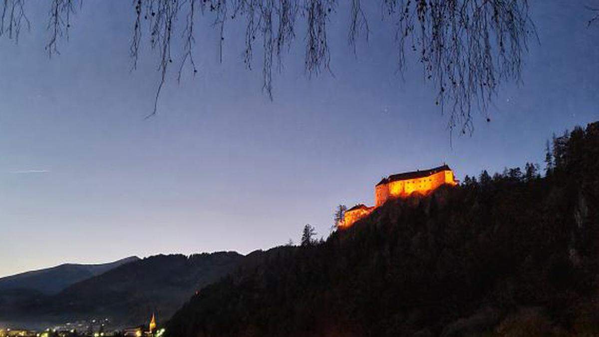 Die Burg Rothenfels wird orange beleuchtet