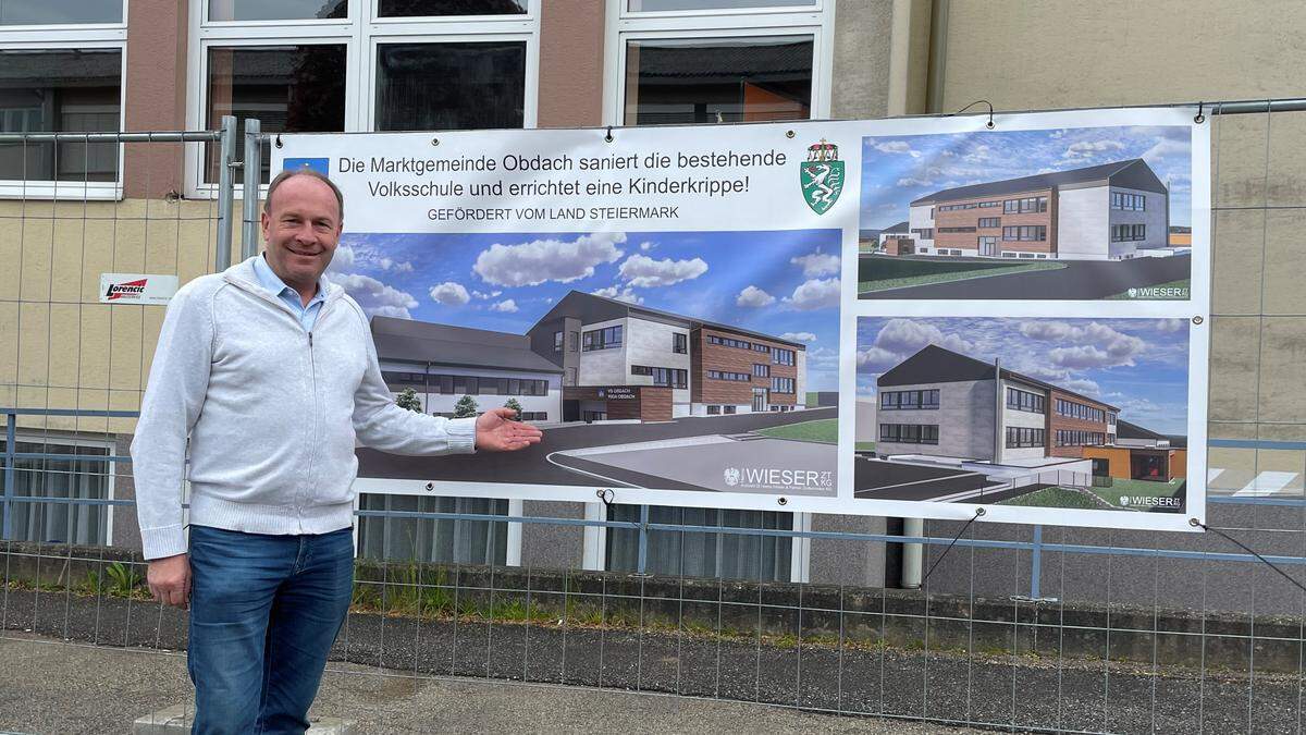 Bürgermeister Peter Bacher vor den Plänen der sanierten Volks- und Musikschule sowie des Kinderkrippen-Zubaus