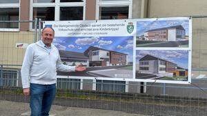 Bürgermeister Peter Bacher vor den Plänen der sanierten Volks- und Musikschule sowie des Kinderkrippen-Zubaus