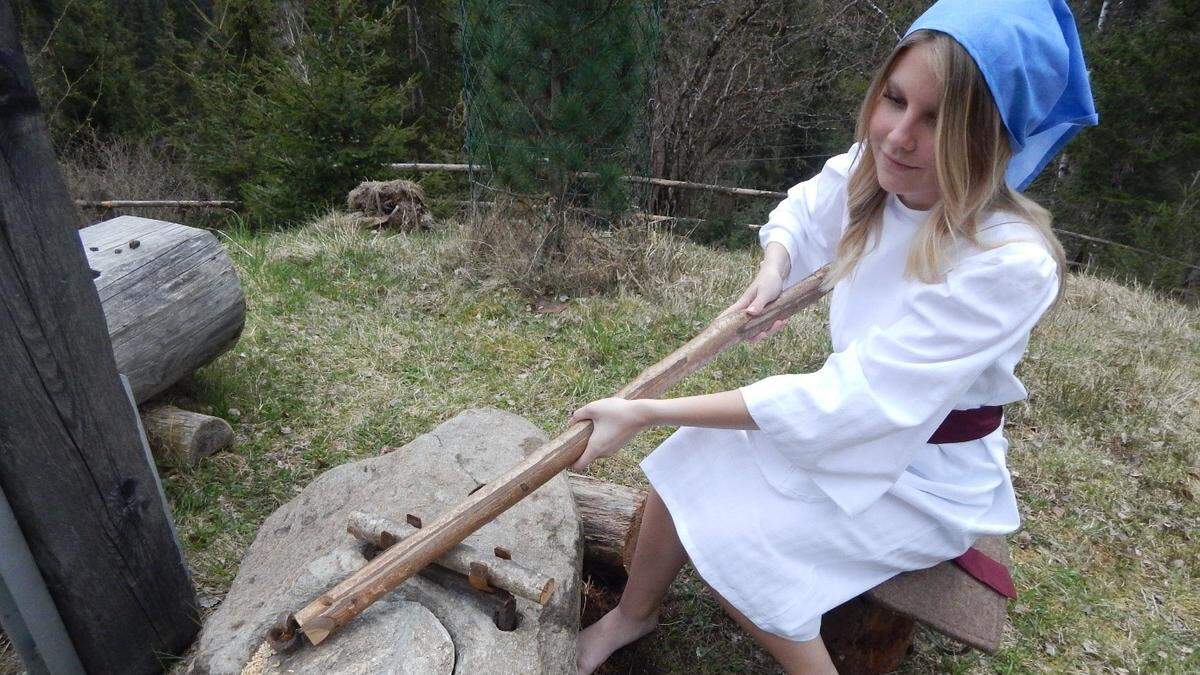 Magdalena zeigt auf diesem Bild vor, wie mit dem Stein vermutlich gemahlen wurde 