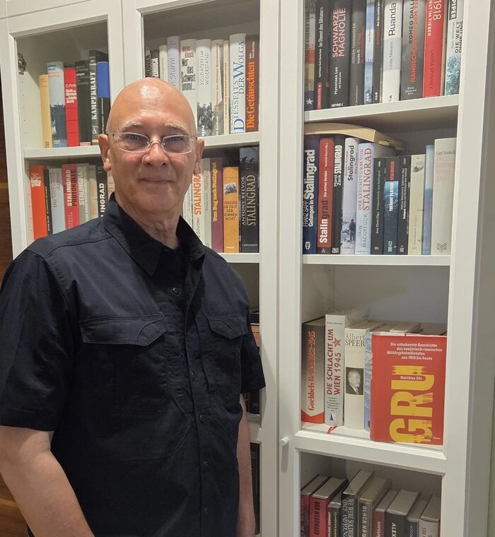 Joe Posch vor seiner fast 1000 Bücher zählenden Bibliothek