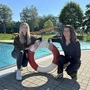 Lisa Peyer (links) und Daniela Zrim (rechts) kniend vor dem Pool des Freibades Söchau, in ihrer Mitte ein rot-weißer Rettungsring