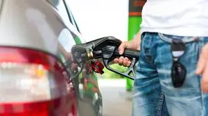 Refuel the car on a gas station; man holding the tap