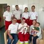 Notfallsanitäterin Verena Prinz mit Isabella im Arm, ihren Eltern und ihrem großen Bruder sowie dem restlichen Roten Kreuz-Einsatzteam