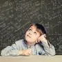 Cute smart child student on blackboard background with science formulas. Learning science concept. 