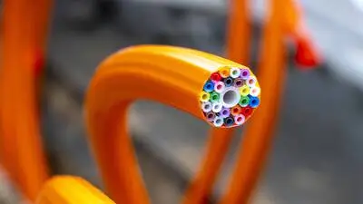Schutzrohr in Orange, darin sind die Leerrohre für die eigentlichen Glasfaserkabel, die dann später eingeblasen werden. Jedem Haushalt wird ein farbiges Rohr zugewiesen und an den Glasfaser-Knotenpunkt angeschlossen
