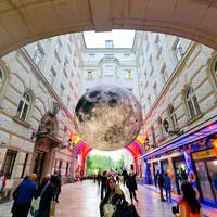 Mondskulptur über einer Straße in Budapest, wo der Urlaubseuro – theoretisch – das Eineinhalbfache wert ist