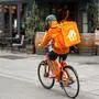 Vienna, Austria, August 23, 2022. A rider from Lieferando, home delivery company for food and drink. It is easy to notice them: the showy orange duffel bag with the typical white logo.