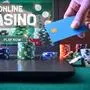 Casino game player accessing a payment card to make virtual bets using a laptop. Front view.