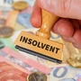 Stempel mit der Aufschrift „insolvent“; Geldscheine