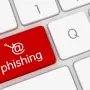 Eine Computer-Tastatur mit einem @-Zeichen zeigt eine rote Taste auf der „Phishing“ steht | In der E-Mail-Flut mehren sich auch Phishing-Versuche