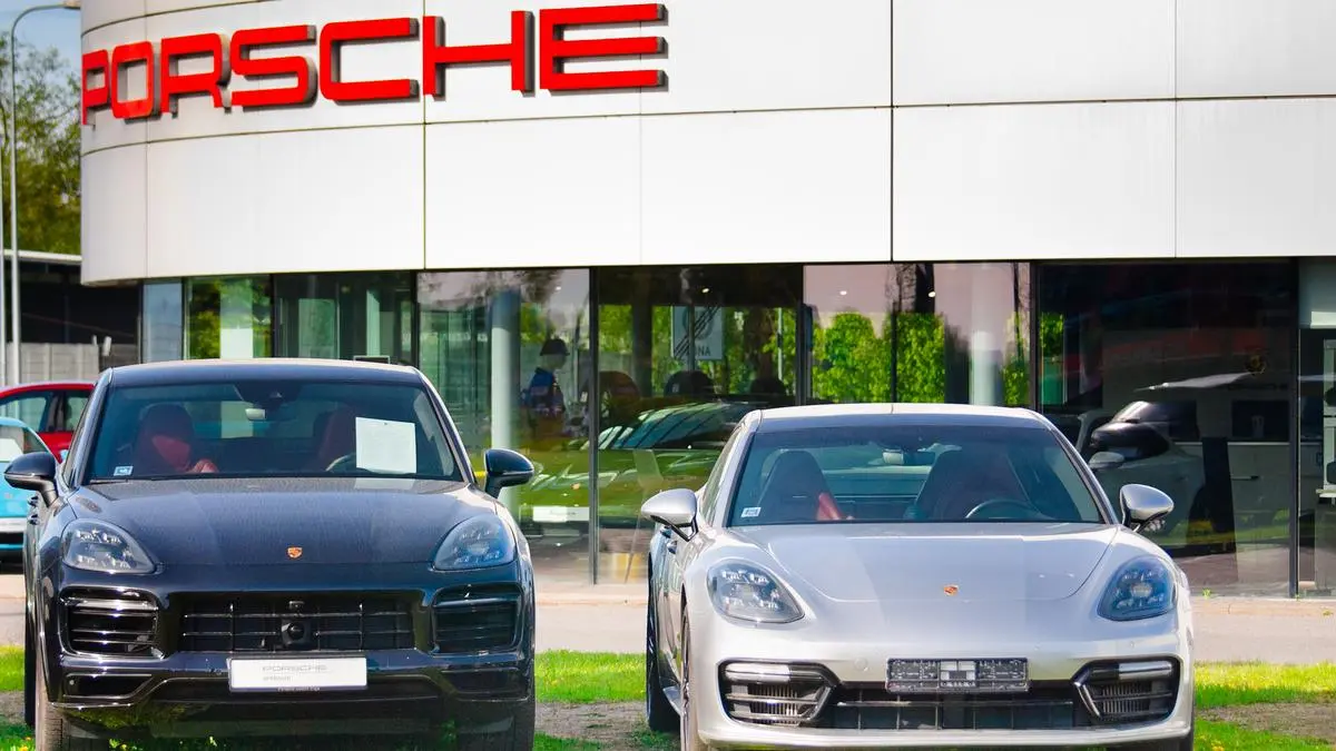 Riga, Latvia - May 12, 2024: New Porsche cars on the street near the car dealership in the background is a dealership with the Porsche inscription.